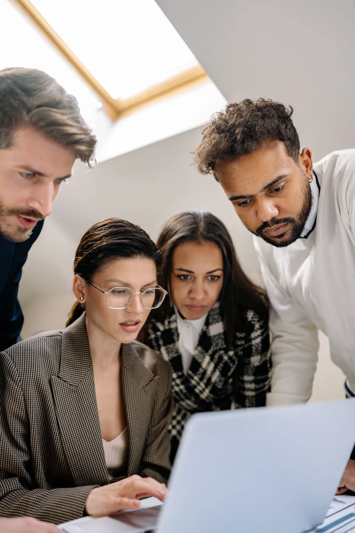 Ein Team schaut gemeinsam auf einen Laptop – praxisnahe Umsetzung von KI und Automatisierung